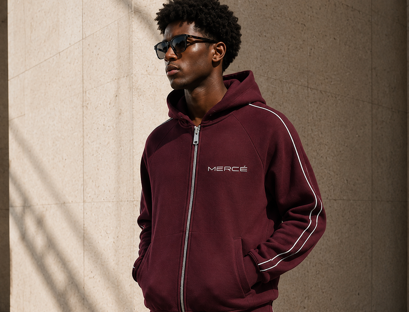MERCÉ zip hoodie styled in shadowed architectural corridor at night